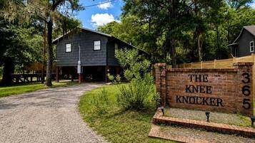 A rustic building labeled 'The Knee Knocker' with a gravel driveway leading to it.