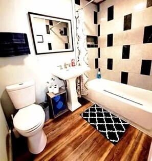 A bathroom with a toilet, sink, and bathtub.