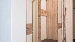 Een moderne badkamer met een houten wastafelmeubel, een bankje en een spiegel.