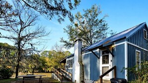 A rustic building with a wooden deck, a staircase, and a picnic table.
