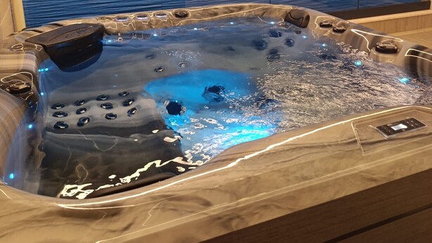 A hot tub with a view of a calm body of water and a sunset. - Beachfront penthouse Pearl (Povljana)