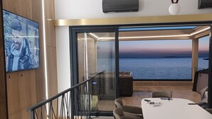 A modern meeting room with a large table, comfortable chairs, a TV, and a view of the sea. - Beachfront penthouse Pearl (Povljana)