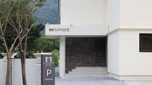 Entrada moderna de un hotel con pared de piedra y escalones que conducen a la puerta.
