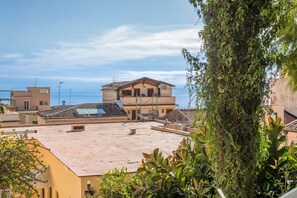 Un edificio residenziale con tetto piatto, diversi balconi e vista sul mare.