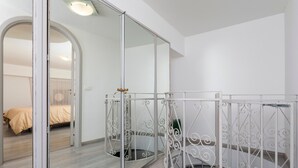 Ein Schlafzimmer mit einem Spiegelkleiderschrank, einem Bett und einer Treppe.