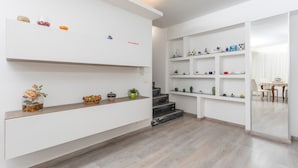 Ein modernes Interieur mit Treppe, weißen Wänden und Regalen mit Dekorationselementen.