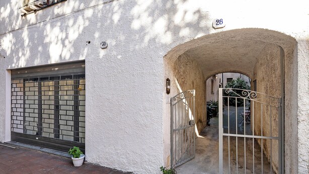 A building entrance with a metal gate, a potted plant, and a number '28' sign. - Apartment 'La Casa di Iris with Parking Space', Wi-Fi and Air Conditioning (Diano Marina)