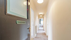 A hallway with a carpeted floor, a door labeled "SCOTSHOP," and a light fixture on the ceiling. - Scosthrop - Bridge End Mill By Guestz (Settle)