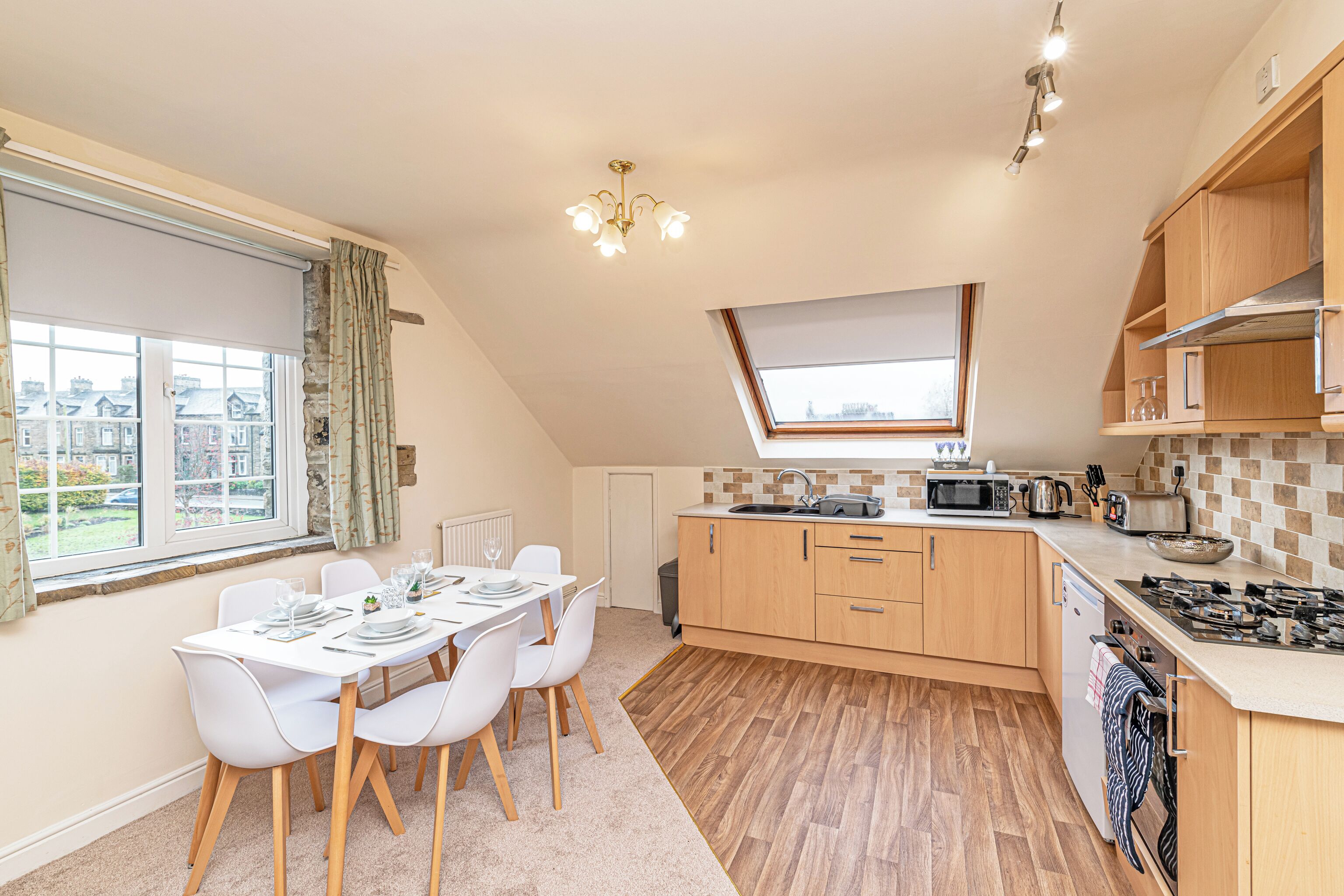Une cuisine moderne avec un coin repas, des meubles en bois, un four à micro-ondes et une vue sur la ville.
