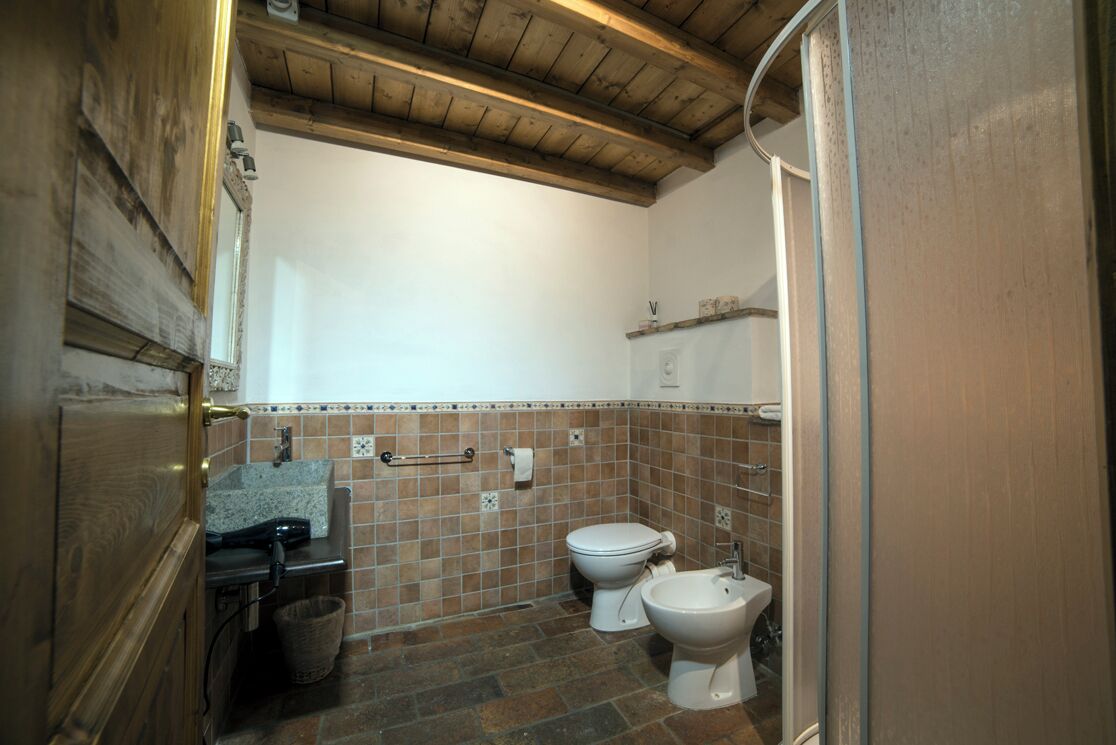 Un bagno con due servizi igienici, un lavandino e una doccia.