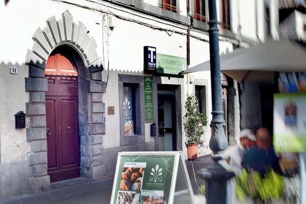 Un edificio con puerta roja y un letrero para restaurante.
