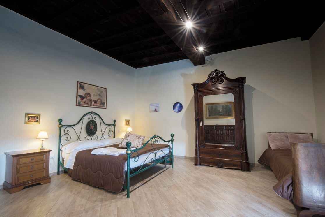 Un dormitorio con cama, cómoda, armario y mesita de noche.