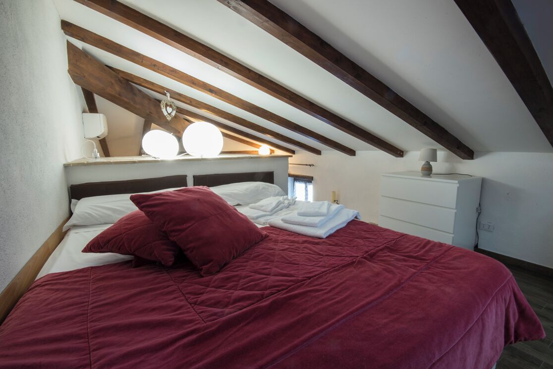 Ein Schlafzimmer mit einem Bett, Kissen, einem Nachttisch und einem Beistelltisch.