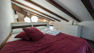 Ein Schlafzimmer mit einem Bett, Kissen, einem Nachttisch und einem Beistelltisch.