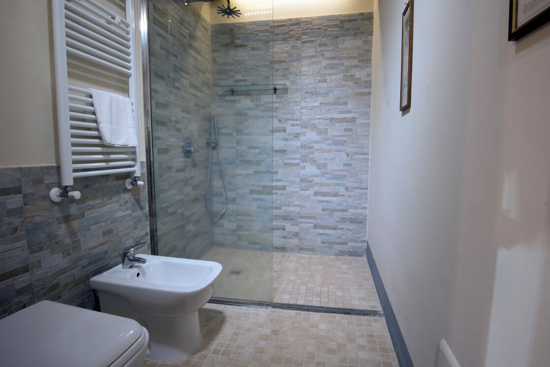 A bathroom with a glass-enclosed shower, a white toilet, and a bidet.
