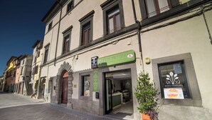 Un edificio con un letrero que anuncia el restaurante "Bona Ventura", con fachada de piedra y una planta en maceta en el exterior.