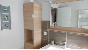 A modern bathroom with a wooden vanity, a large mirror, and a tiled backsplash. - House with heated pool (LAUZACH)