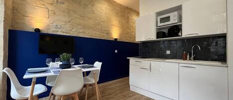 A modern kitchen with white cabinets, a microwave, and a sink.