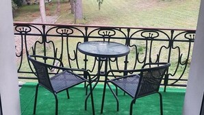 A balcony with a green artificial turf floor, two black metal chairs, and a small round table. - Villa Podkarpacka (Kudowa Zdroj)