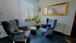 A room with two armchairs, a small round table, and a potted plant. - Villa Podkarpacka (Kudowa Zdroj)