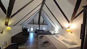 A room with a sloped ceiling, two beds, a desk, and two lamps. - Villa Podkarpacka (Kudowa Zdroj)