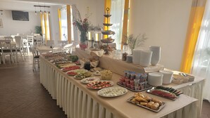 A buffet setup with various food items and a long table covered with a beige cloth. - Villa Podkarpacka (Kudowa Zdroj)