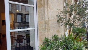 A building with a large window and a potted plant on the ground. - Elegance et confort au centre de Bordeaux (Bordeaux)