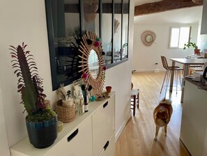Una cocina moderna con piso de madera, un comedor con mesa y sillas, y un espejo grande en la pared.