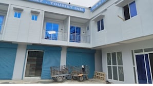 A building with a sign reading "MINIMART TOURIST INN" and "MINIMART SHOP" on the upper level.