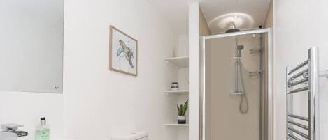 Un bagno moderno con doccia, servizi igienici e lavandino.