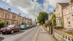 A street lined with terraced houses, parked cars, and a clear sky. - The Design Studio Apartment (Bath)