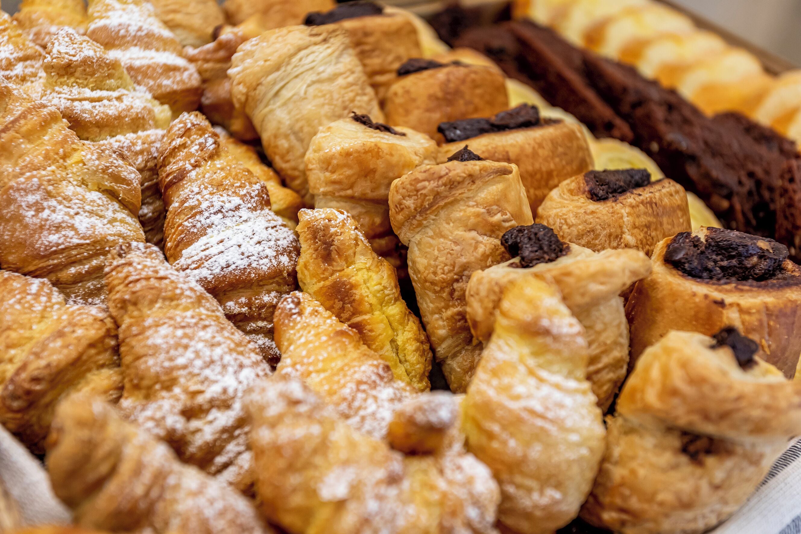 A variety of pastries including croissants and chocolate-topped pastries.