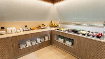 A buffet area with various food items and utensils.