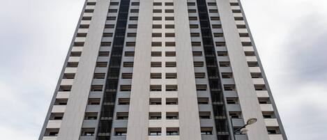 Un edificio alto y moderno con una fachada de ventanas y balcones.