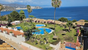 A resort with a pool, palm trees, and a view of the sea. - LUZ DE LA MARINA - Penthouse in Punta de la Mona of La Herradura (Almuñécar) (Almuñécar)