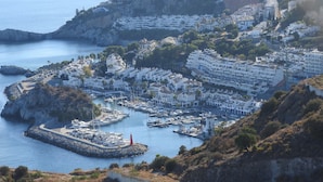 A coastal town with a marina, white buildings, and a lighthouse. - LUZ DE LA MARINA - Penthouse in Punta de la Mona of La Herradura (Almuñécar) (Almuñécar)