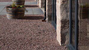 A stone building with arched windows and a gravel pathway. - Remore Steading - The Coach House (Nairn)