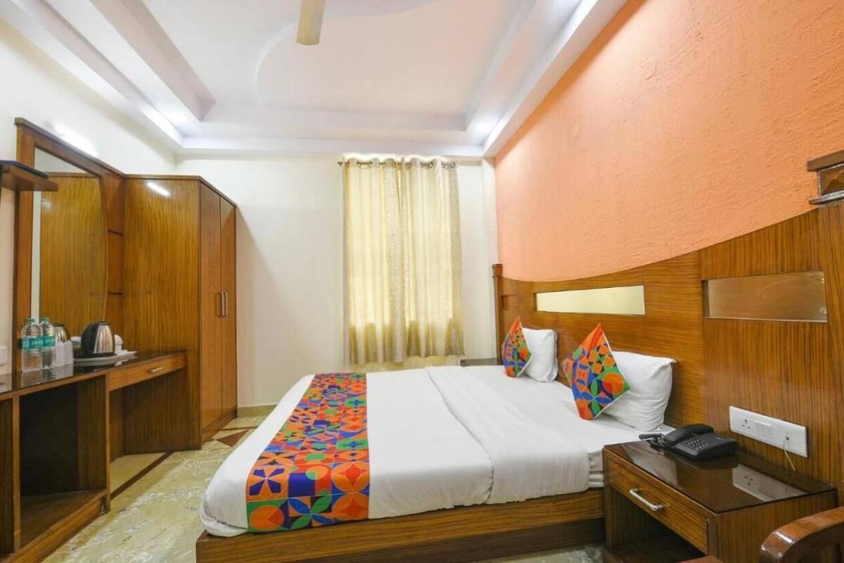 A hotel room with a bed, a desk, a wardrobe, and a bathroom.