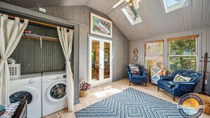 Une buanderie équipée d’un lave-linge, d’un étendoir et d’un ventilateur de plafond.
