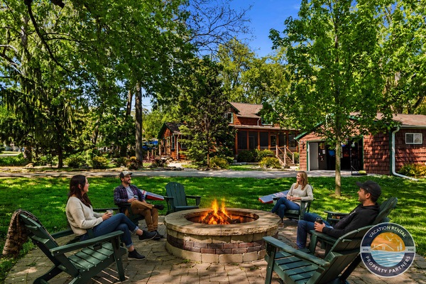 Backyard fire pit with plenty of seating, open yard space, and room to gather under the trees in every season.