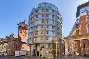 Un hotel de varios pisos con fachada curva, ventanas amplias y una entrada central.