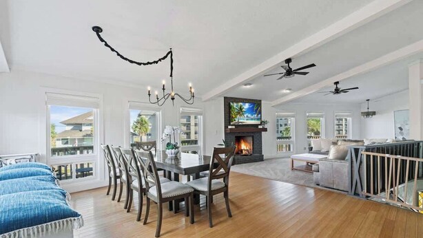 A spacious living room with a fireplace, dining area, and multiple ceiling fans. - Secret Garden Stay - Team Joseph Ellen (Fernandina Beach)