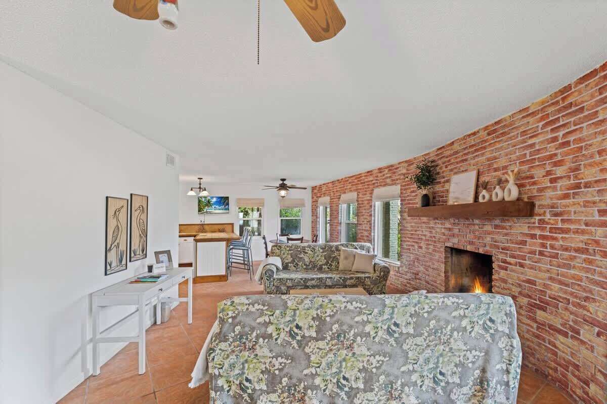 Un amplio salón con chimenea de ladrillo, comedor y cocina.