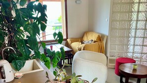 Un salón acogedor con un sofá, una mesa de centro y varias plantas en macetas.