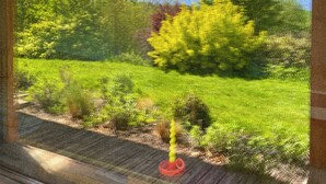 Una habitación con un gran ventanal con vistas a un jardín.