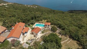 Une propriété située sur la côte, dotée d’une piscine, de maisons en terrasses et offrant une vue sur la mer.