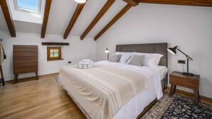 A bedroom with a large bed, wooden beams, a skylight, a bedside table with a lamp, and a small window. - Villa Cangarela (100411-K1) - Visnjan (Porec) (Visnjan (Porec))