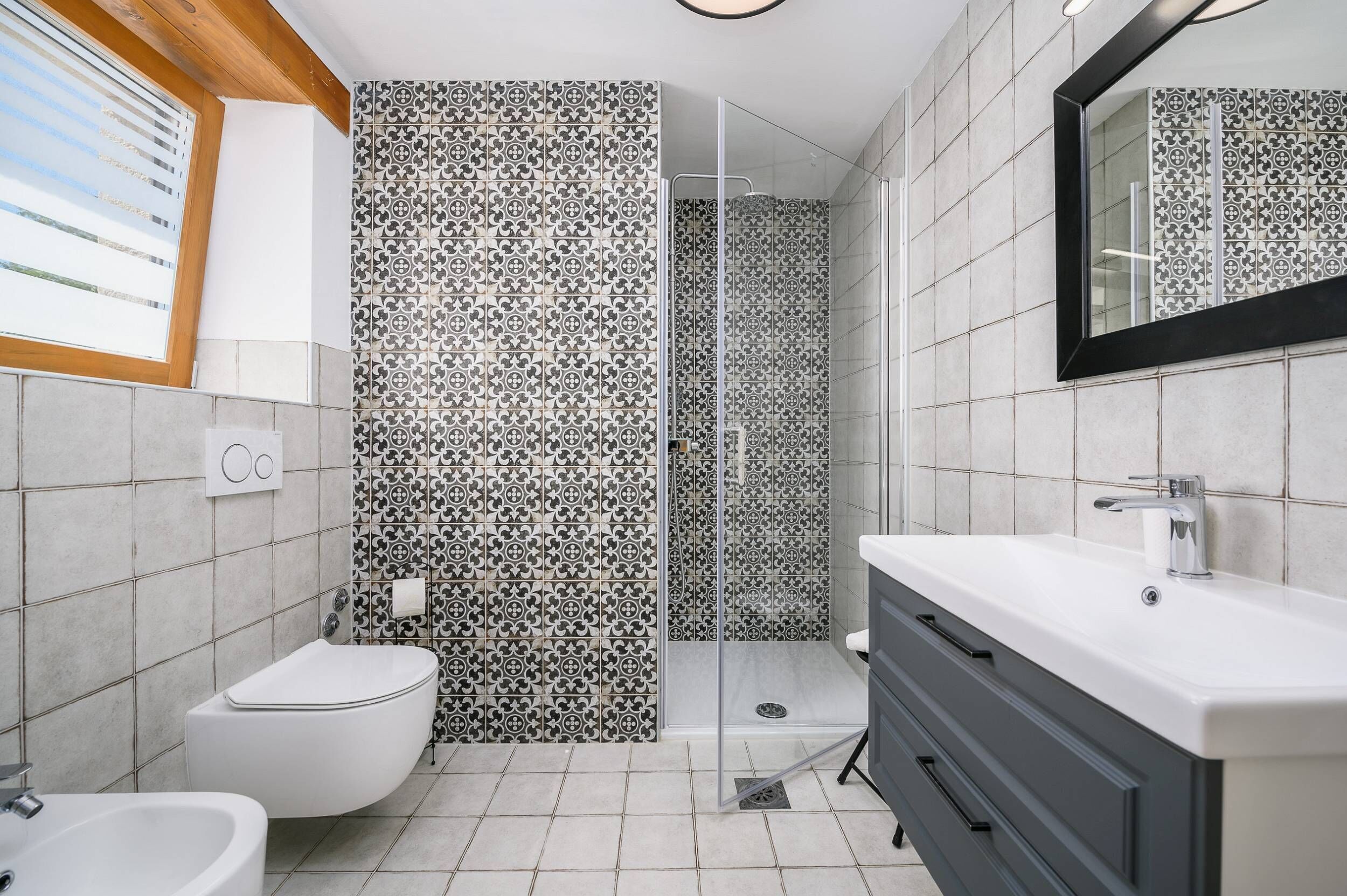 A modern bathroom with a shower, toilet, and sink.