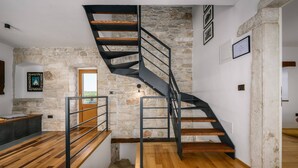 A modern interior with a spiral staircase, stone walls, and wooden flooring. - Villa Cangarela (100411-K1) - Visnjan (Porec) (Visnjan (Porec))