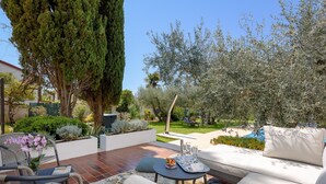 An outdoor patio with a sofa, chairs, and a table set for dining.